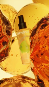 a bottle of orange juice with a bottle in the background